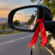 O que significa encontrar uma fita vermelha amarrada no retrovisor de um carro na estrada?