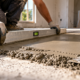 Mestre de obras mostra como corrigir piso irregular usando argamassa de reparo e técnica de nivelamento para preparar a superfície antes do revestimento