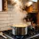 Ferver água com vinagre e rodelas de limão destampada: o vapor potente que dissolve a gordura dos armários altos da cozinha sem esfregar