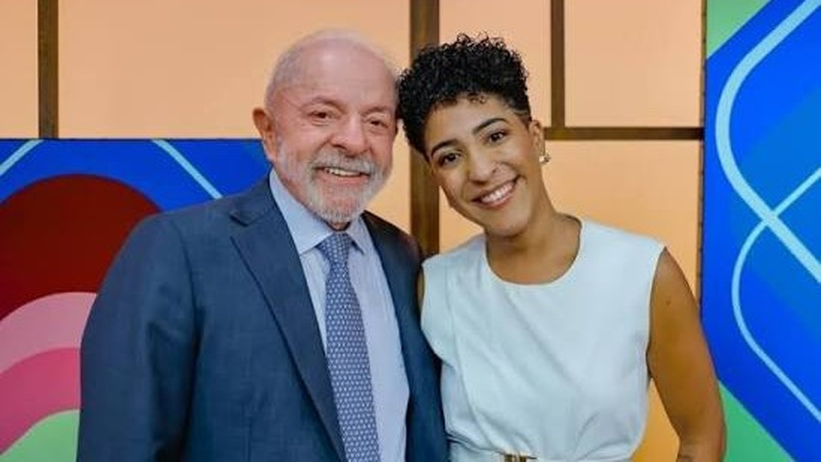 Presidente Lula, de barba branca, e mulher sorridente com cabelo curto encaracolado