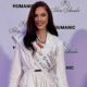 Mulher sorrindo, vestindo blazer branco e faixa "AUSTRIA 2024", fundo com logotipos "HUMANIC" e "Silvia Schneider"