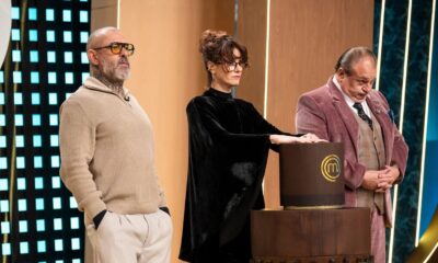 Três jurados em set de TV com pódio MasterChef, esperando decisão