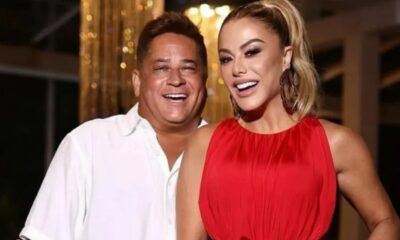 Leonardo e Poliana Rocha sorriem amplamente, ele de camisa branca, ela de vestido vermelho