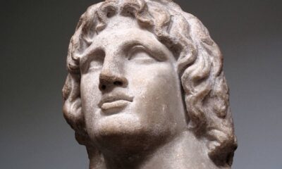 Busto de mármore de Alexandre, o Grande, com cabelo encaracolado, olhando para cima.