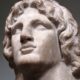 Busto de mármore de Alexandre, o Grande, com cabelo encaracolado, olhando para cima.