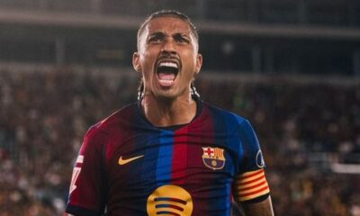 Raphinha do Barcelona celebra vestindo camisa azul e vermelha listrada em campo