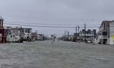 Rua com casas em Surf City, Nova Jersey, completamente inundada sob céu cinzento