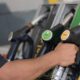 Mão segura bico de bomba de combustível 'B7 diesel' em posto, com 'diesel' visível