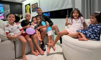 MC Poze do Rodo e seis crianças sorrindo em um sofá com lollipops e balão