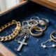 Variadas joias de ouro e prata, incluindo anéis, correntes e brincos, misturadas em uma caixa de veludo azul