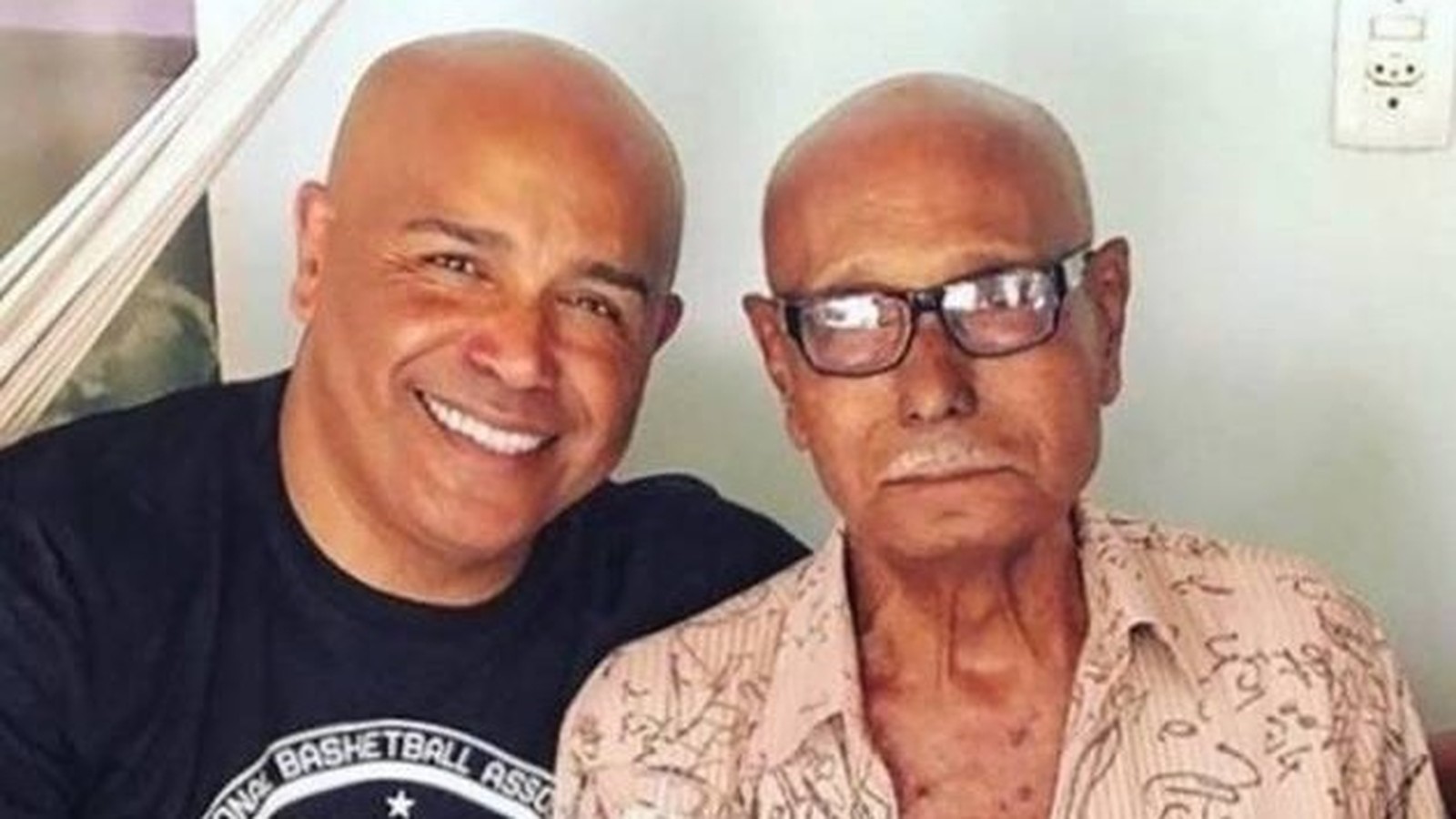 Rick Sollo sorrindo com o pai, Vítor Antônio de Carvalho, de óculos