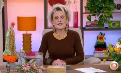Ana Maria Braga, óculos, blusa marrom, sentada em estúdio, Louro José, estátuas, logo AO VIVO