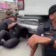 Policial fardado e alunos da PM abrigados no chão ao lado de veículo da corporação no RJ
