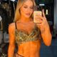 Bruna Griphao em selfie de espelho, vestindo top dourado de paetês, segurando celular, em bastidores