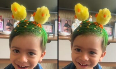 Menino sorrindo com cabelo verde decorado com milho e dois pintinhos de brinquedo na cabeça
