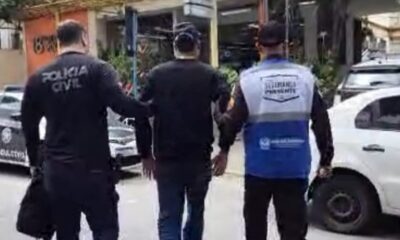 Três homens de costas: um policial civil, um preso e um agente de segurança pública