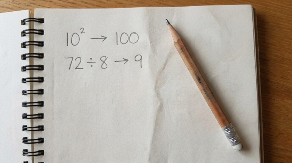 Folha de caderno com as primeiras etapas da expressão 10² − 72 ÷ 8 × 3 organizadas, sem revelar o resultado final.