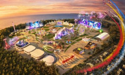 Vista aérea do festival Rock in Rio com palcos, atrações, multidão, fogos e aviões no pôr do sol