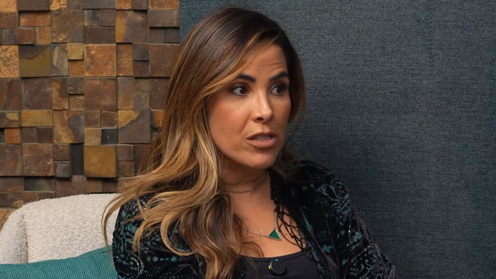 Wanessa Camargo, em close-up, falando, com cabelo castanho e colar com pingente verde
