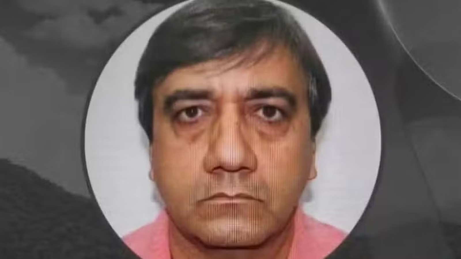 Rosto de homem, cabelo escuro e liso, camisa rosa, em foto de perfil circular