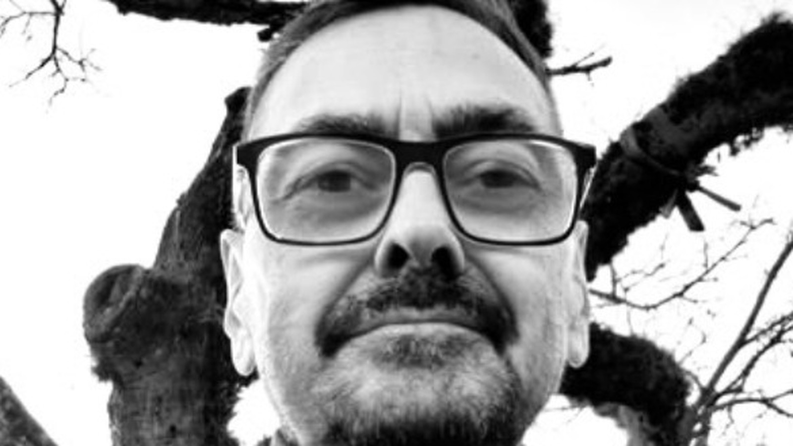 Retrato em preto e branco de homem com óculos, bigode e barba