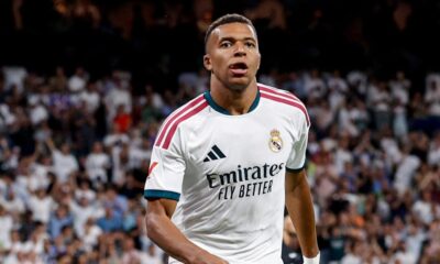 Kylian Mbappé com camisa branca do Real Madrid e logos "Emirates FLY BETTER" e Adidas