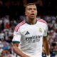 Kylian Mbappé com camisa branca do Real Madrid e logos "Emirates FLY BETTER" e Adidas