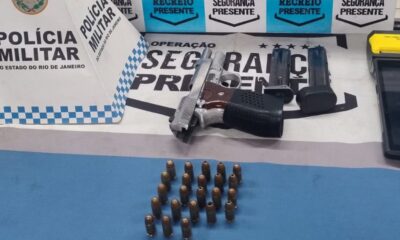 Pistola prateada, 23 munições, dois carregadores, máquina de cartão e logo Polícia Militar