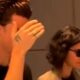 Shawn Mendes com a mão no rosto, ao lado de Bruna Marquezine de óculos escuros