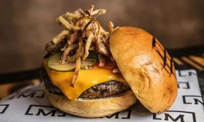 Hambúrguer gourmet com carne, queijo derretido, picles, cebola crocante e pão tostado