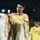 Cristiano Ronaldo, em campo, veste túnica árabe branca e dourada sobre camisa amarela