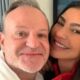Close-up de Rubens Barrichello e Cíntia Chagas sorrindo para a câmera, abraçados