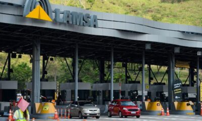 Praça de pedágio da Linha Amarela com sinalização LAMSA, dois carros e funcionário