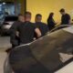 Homens próximos a viatura policial branca com número 67-234 no teto, em operação noturna