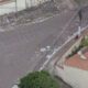 Rua de paralelepípedos e telhados vista de cima, com muitos papéis espalhados