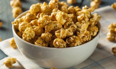 Pipoca doce caramelizada em tigela branca sobre pano xadrez e superfície de madeira