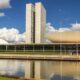 Congresso Nacional do Brasil com torres gêmeas, cúpula, bacia invertida, lago e céu azul