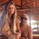 Tiririca e Nana Magalhães em varanda de madeira. Ele de óculos, ela com cabelo loiro, segurando copo