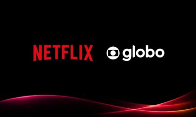 Logos Netflix em vermelho e Globo em branco, em fundo preto com linhas curvas vermelhas