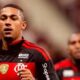 Homem em uniforme preto e vermelho do Flamengo com logos BRB e Shopee, outro jogador desfocado ao fundo.