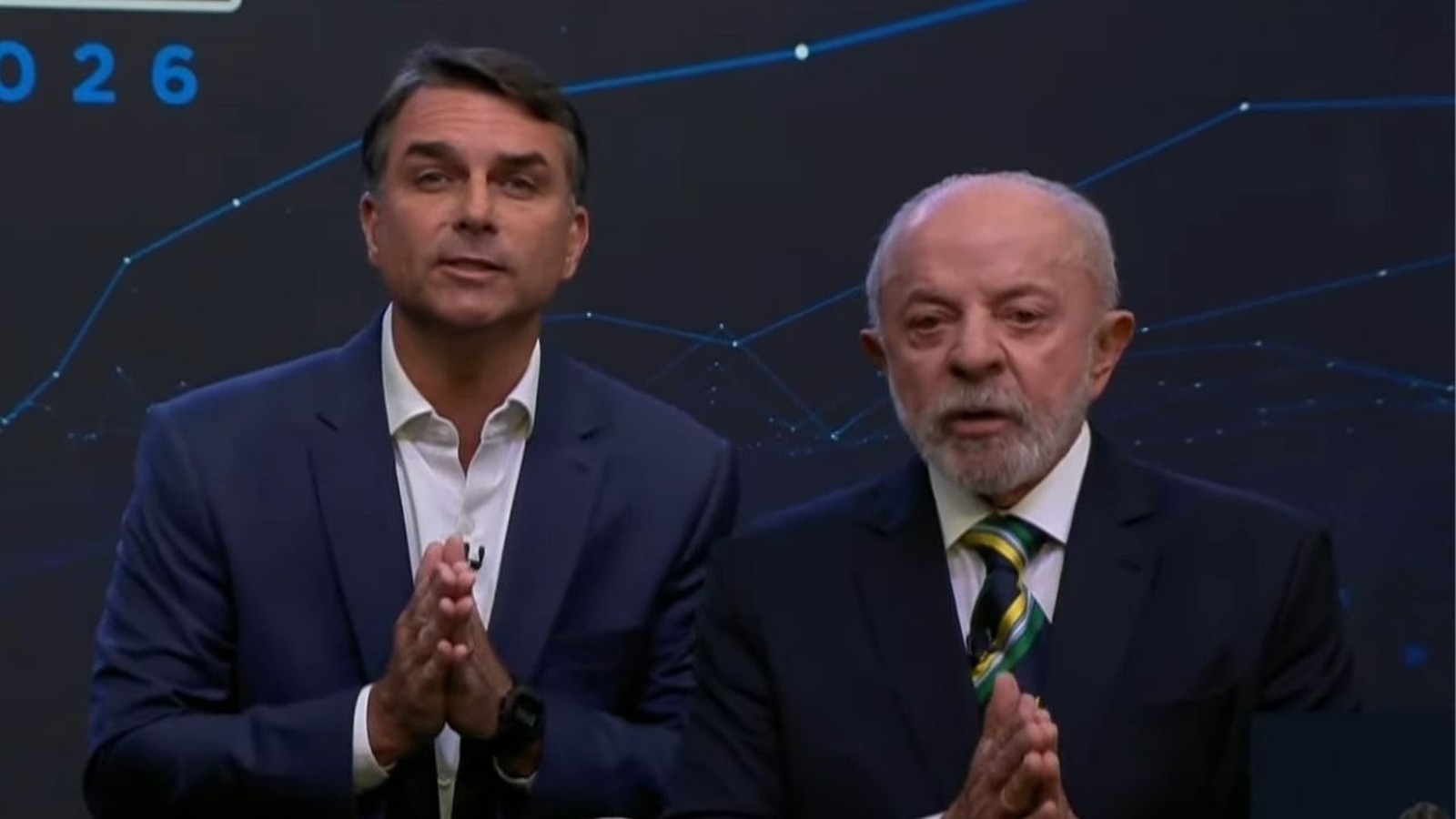 Luiz Inácio Lula da Silva e Jair Bolsonaro, em trajes formais, com mãos postas.