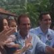 Eduardo Paes e família sorrindo, acenando, com broches de campanha '5' e '555'