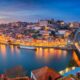 Vista noturna do Porto, Portugal, com rio Douro, ponte Dom Luís I e edifícios iluminados