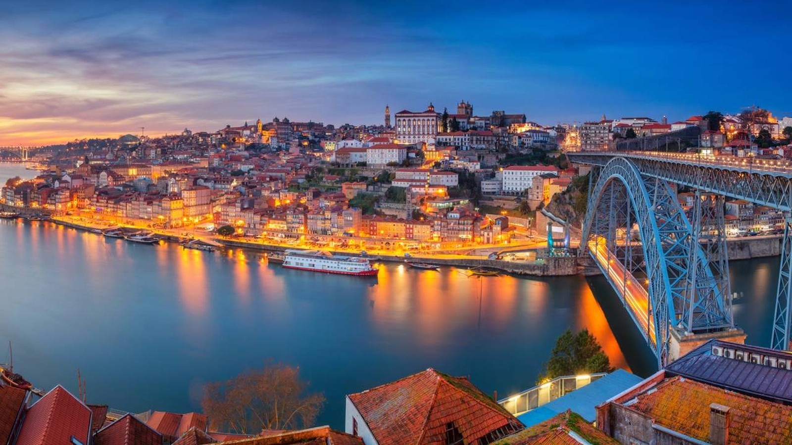Vista noturna do Porto, Portugal, com rio Douro, ponte Dom Luís I e edifícios iluminados