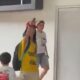 Mulher de camisa amarela, boné vermelho, faz saudação nazista perto de criança