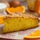 Fatia de bolo de laranja com cobertura crocante, em prato e rodelas de laranja