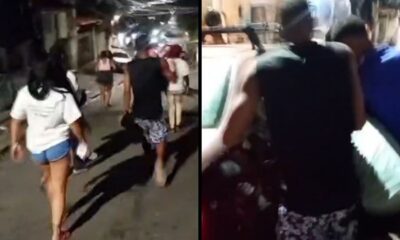Pessoas em rua escura colocam alguém dentro de carro particular à noite