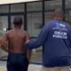 Dois agentes da Ordem Pública escoltam jovem sem camisa. Logos 'Rio Ordem Pública'