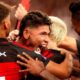 Jogadores do Flamengo em camisa preta e vermelha celebram efusivamente um gol