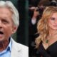 Michael Douglas, cabelos brancos, falando ao microfone e Julia Roberts, cabelo loiro, usando colar de esmeralda